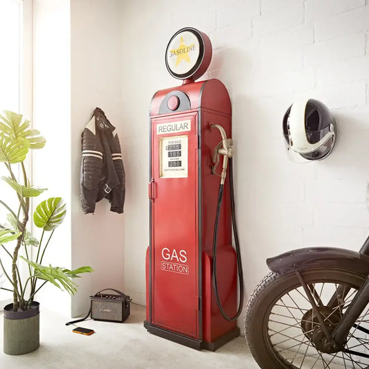 Vintage gas station pump with red color, surrounded by plants, leather jacket, and a motorcycle in a home setting.