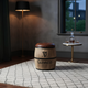 Barrel Stool with Guinness barrel design, brown leather seat, white rug, floor lamp, side table with decanter, and glasses.