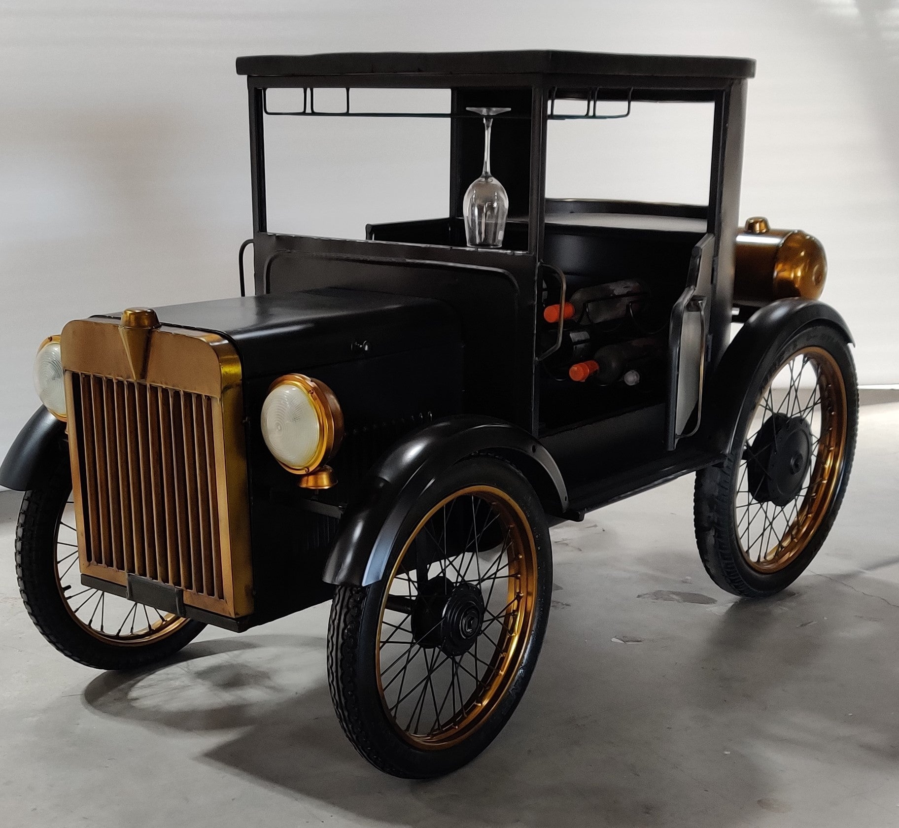 Antique-style car bar with a wooden surface and vintage wheels