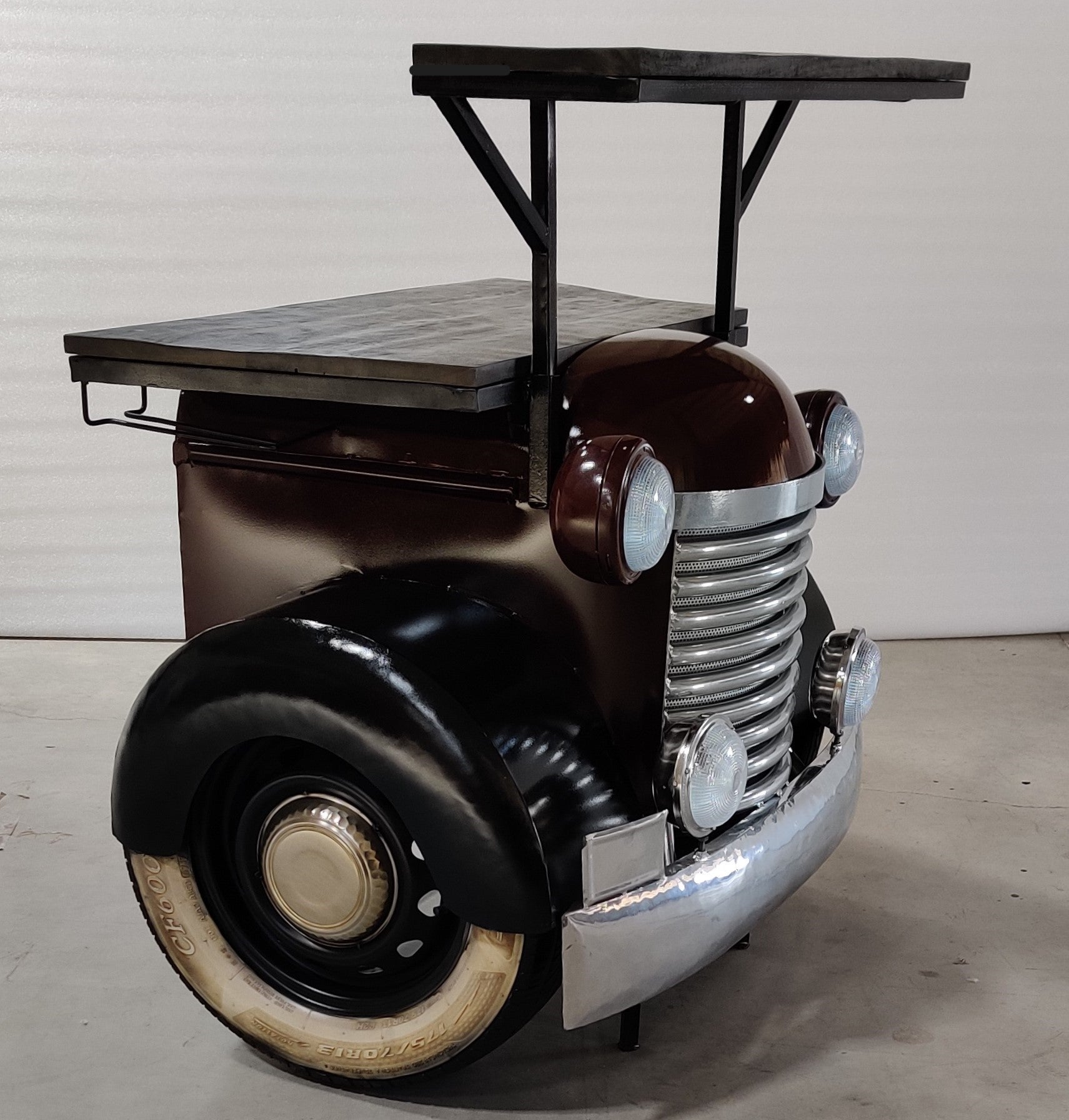 Vintage truck-inspired bar counter with headlights and a metal roof.